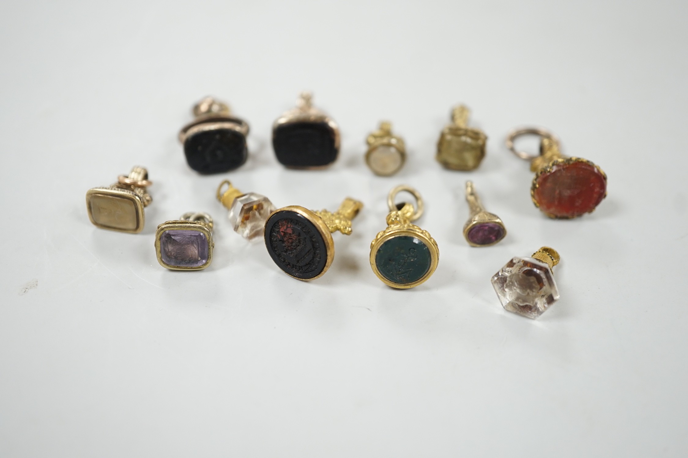 A collection of twelve small 19th century mainly yellow metal fob seals, with assorted matrices including bloodstone, amethyst, citrine and carnelian, largest 22mm.